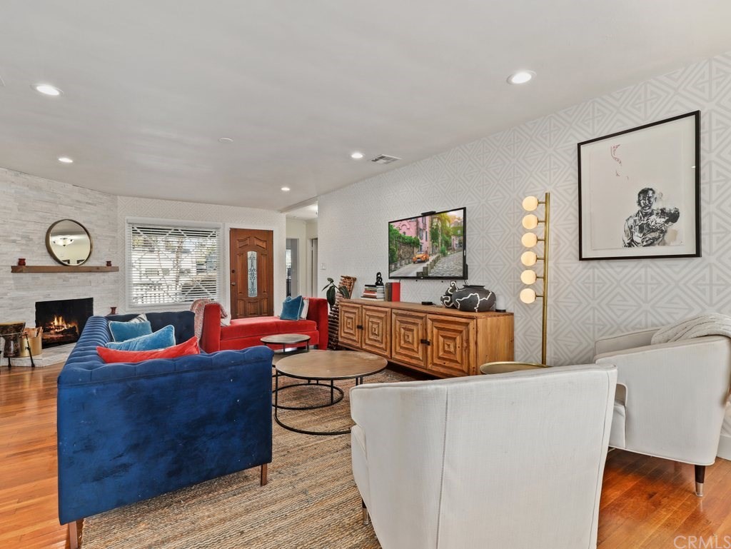 7356 Leescott Avenue Van Nuys, CA 91406 - Photo 4 of 31 a living room with furniture a clock and a flat screen tv