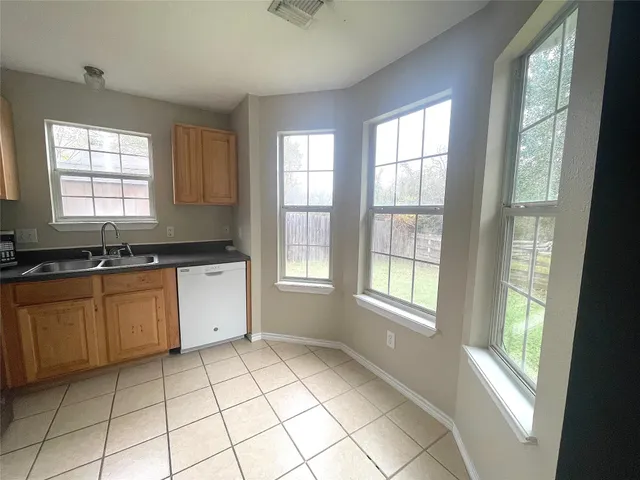 a large kitchen with a window a sink and cabinets