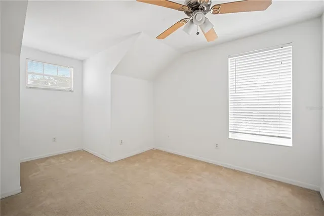 an empty room with a window and a fan