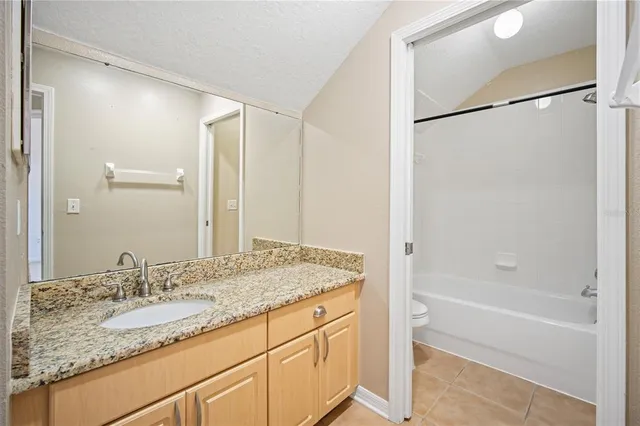a bathroom with a granite countertop sink mirror and a bathtub