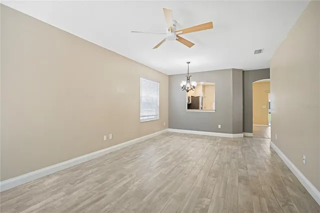 an empty room with windows and fan