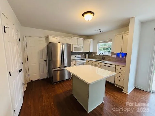 a kitchen with stainless steel appliances a refrigerator sink and cabinets