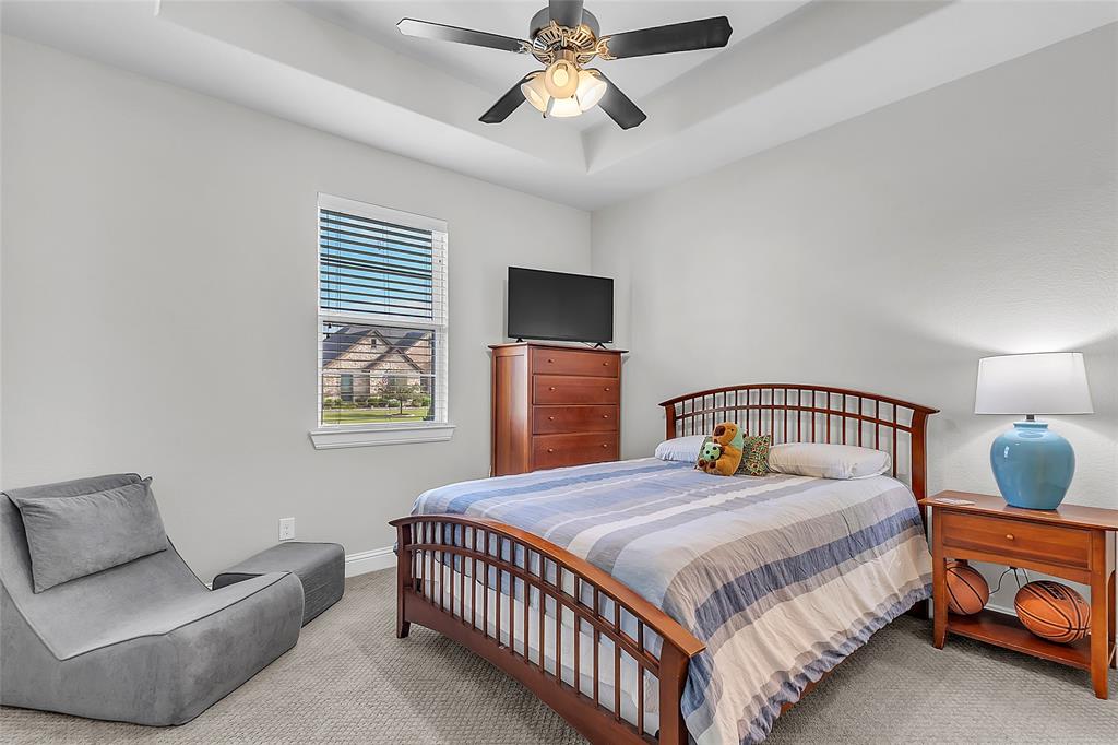 1014 Rennard Street Caddo Mills, TX 75135 - Photo 22 of 39 Carpeted secondary bedroom featuring a tray ceiling, ceiling fan with light, single window with blinds, and light gray wall color