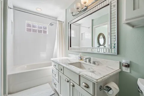 a bathroom with a sink a toilet a mirror and shower