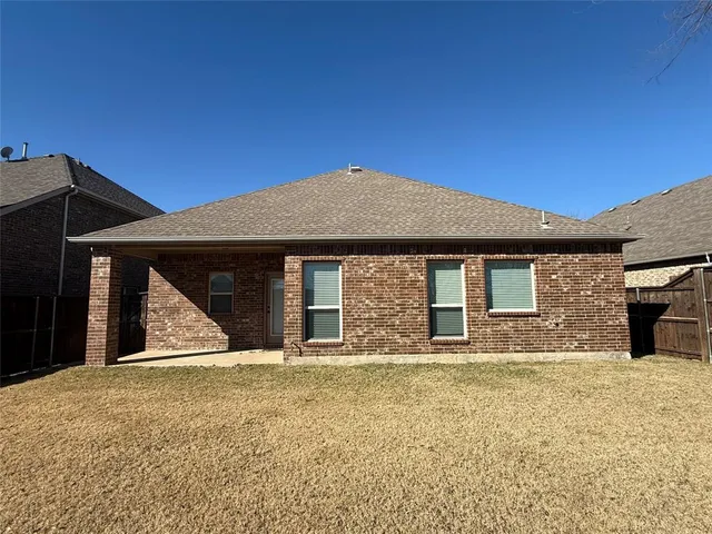 a front view of a house with large trees