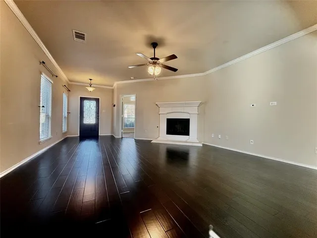 a view of empty room with wooden floor and fireplace
