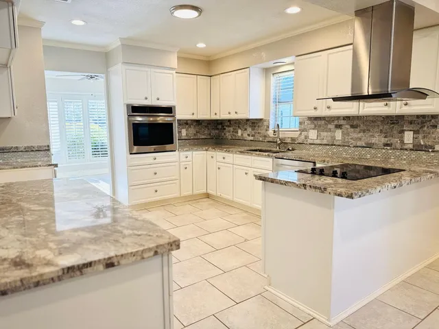 a kitchen with stainless steel appliances granite countertop a stove a sink and a microwave