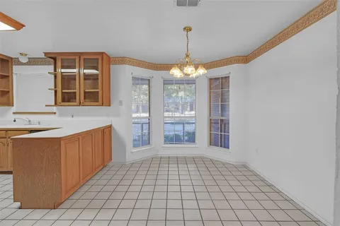 a very nice looking empty room with a fireplace and a chandelier