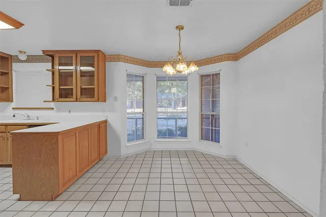 a very nice looking empty room with a fireplace and a chandelier