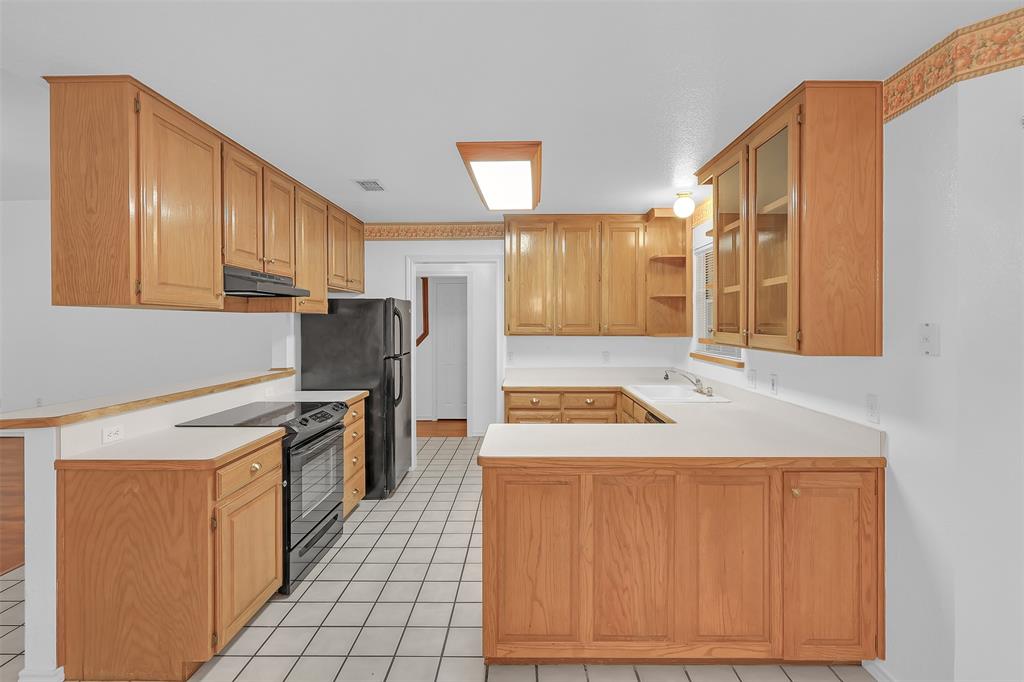 1108 Pine Ridge Drive Azle, TX 76020 - Photo 13 of 40 a kitchen with a stove a sink and a refrigerator