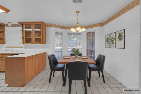 a dining room with chandelier fan and wooden furniture