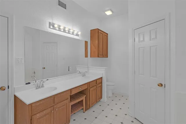 a bathroom with a sink a toilet a mirror and shower