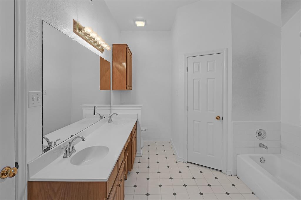 1108 Pine Ridge Drive Azle, TX 76020 - Photo 25 of 40 a bathroom with a sink a mirror and a bathtub