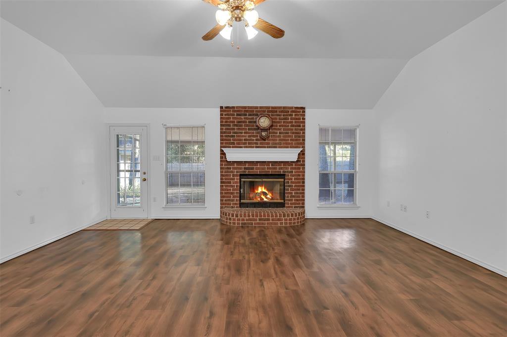 1108 Pine Ridge Drive Azle, TX 76020 - Photo 9 of 40 a view of an empty room with wooden floor fireplace and a window