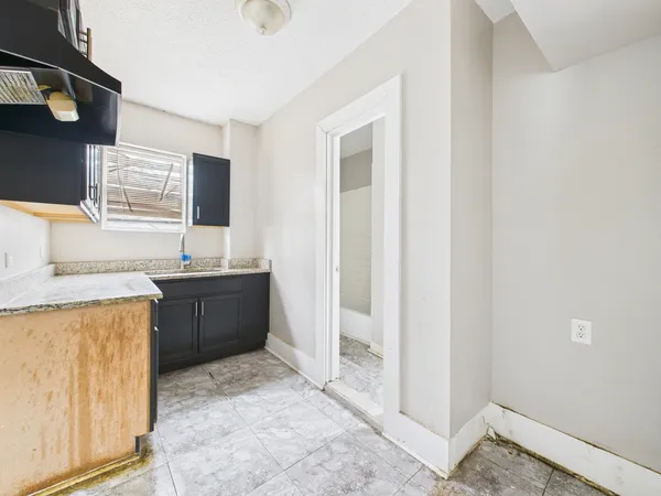 a kitchen with stainless steel appliances granite countertop a sink and a stove top oven with wooden floor