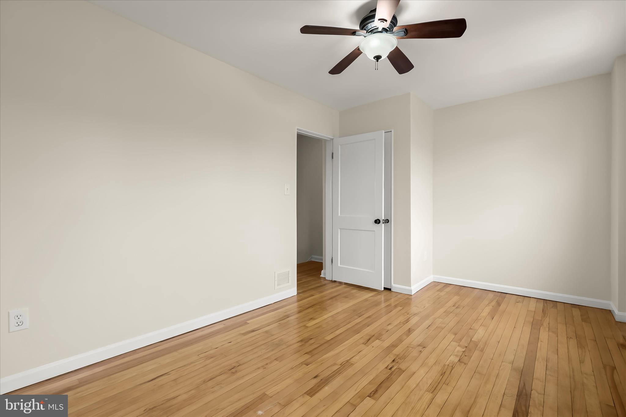 8307 Ridgely Oak Road Baltimore, MD 21234 - Photo 12 of 30 an empty room with wooden floor ceiling fan and windows