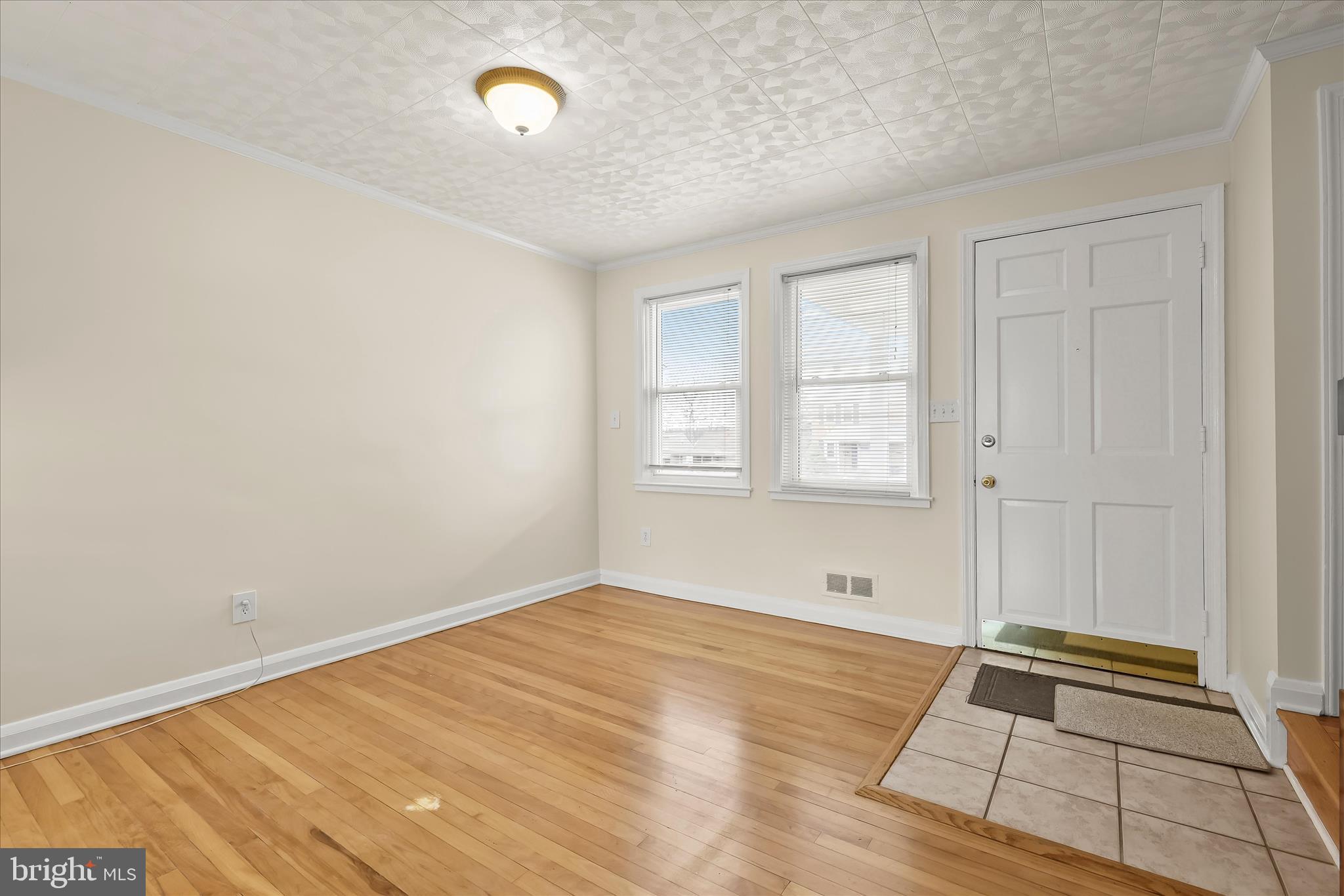 8307 Ridgely Oak Road Baltimore, MD 21234 - Photo 4 of 30 a view of an empty room with window and wooden floor