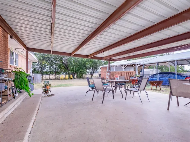 a view of a patio with a table and chairs under an umbrella