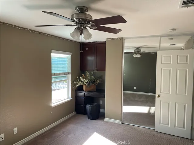 a view of a livingroom with a chandelier fan and windows