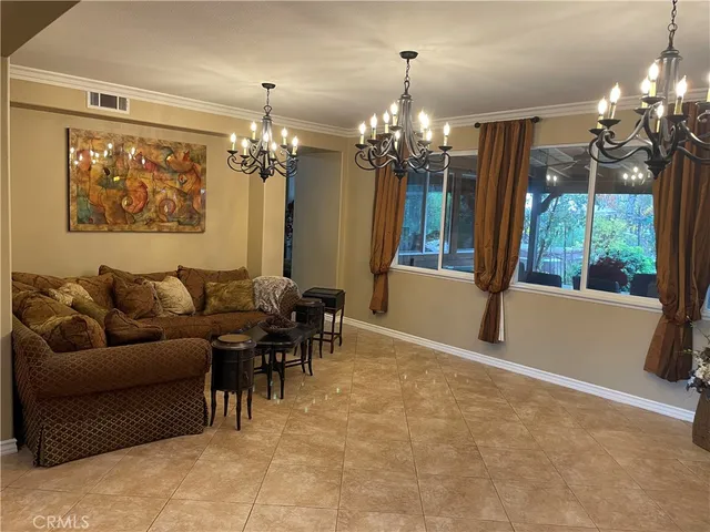 a living room with furniture a chandelier and a dining table