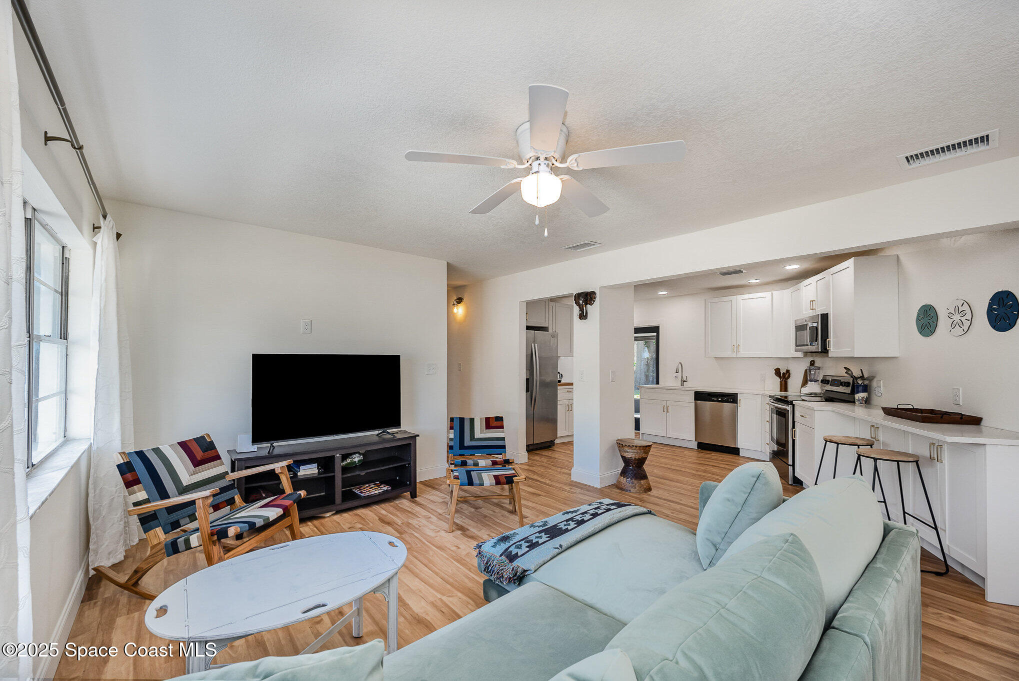 233 Beverly Road Cocoa, FL 32922 - Photo 3 of 20 a living room with furniture a flat screen tv and a window