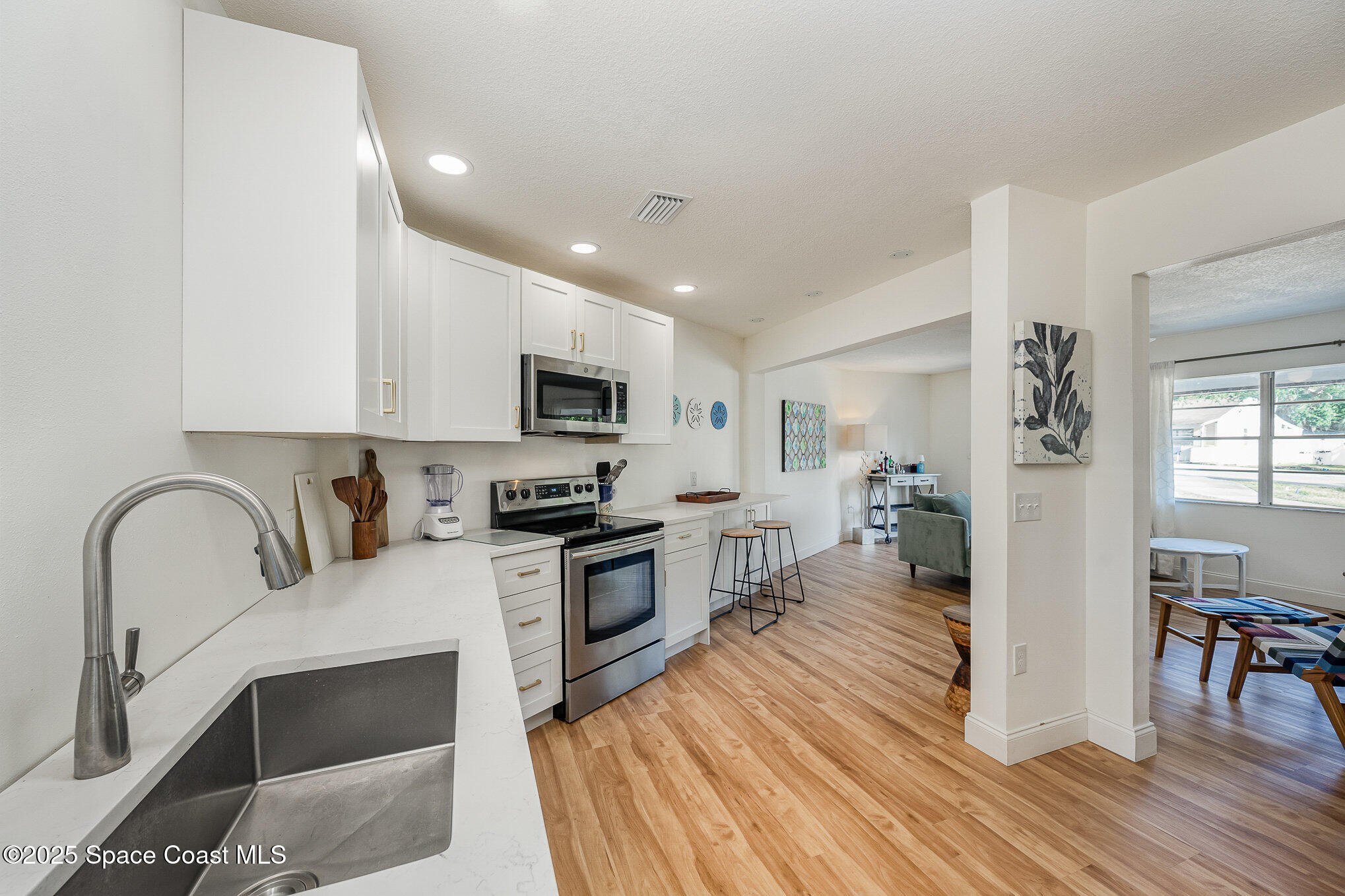 233 Beverly Road Cocoa, FL 32922 - Photo 7 of 20 a kitchen with granite countertop a stove top oven a sink dishwasher a dining table and chairs with wooden floor