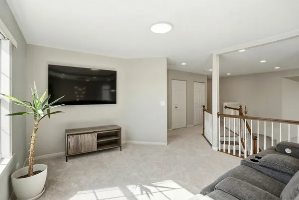 a living room with furniture a flat screen tv and a window