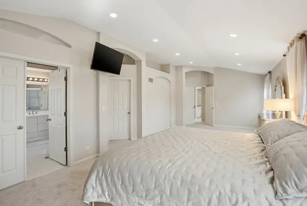 a spacious bedroom with a bed and a flat screen tv