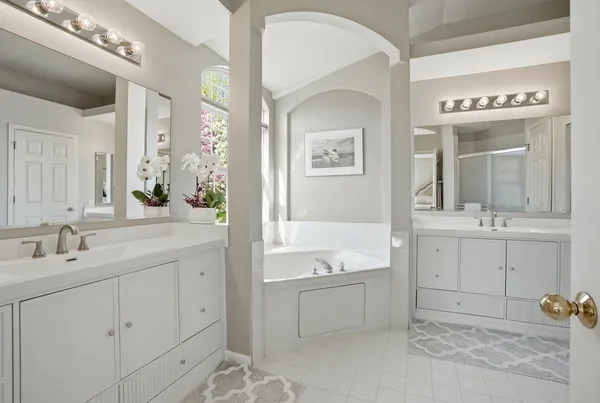a spacious bathroom with a tub sink and mirror