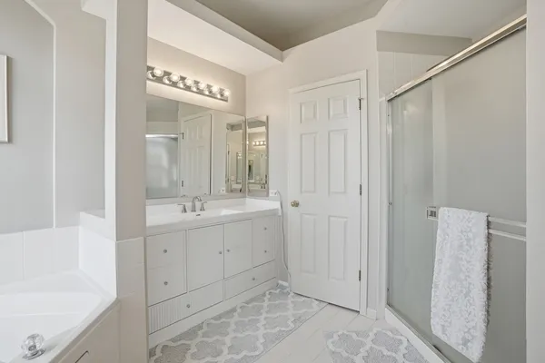 a spacious bathroom with a shower sink and mirror