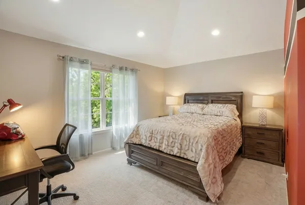 a bedroom with a bed chair and a window