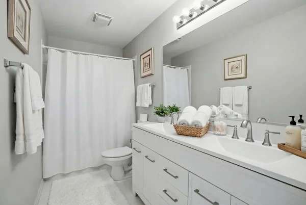a bathroom with a granite countertop sink a toilet and a large mirror