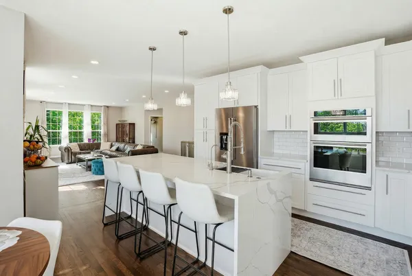 a large kitchen with a table chairs refrigerator and stove