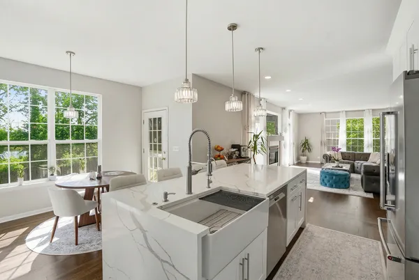 a large white kitchen with a large window and stainless steel appliances