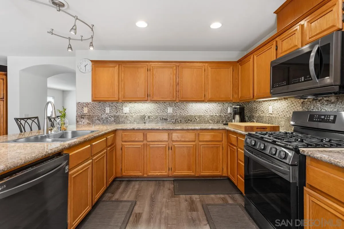 5145 Mendip Street Oceanside, CA 92057 - Photo 12 of 33 a kitchen with stainless steel appliances granite countertop a sink stove and microwave