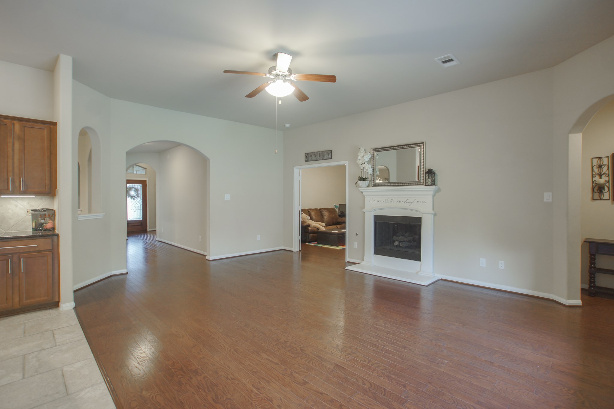 111 Pheasant Run Drive Conroe, TX 77384 - Photo 15 of 50 a view of a livingroom with a fireplace a chandelier and wooden floor