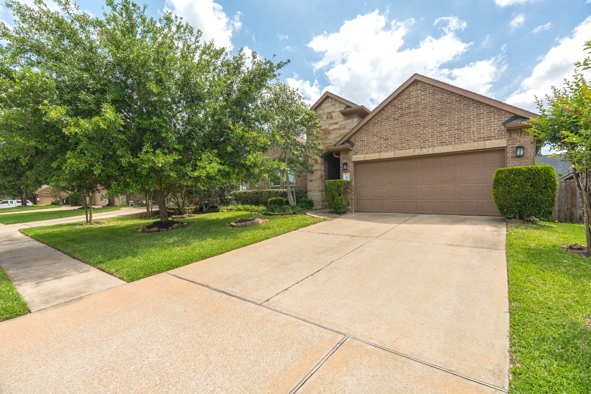 111 Pheasant Run Drive Conroe, TX 77384 - Photo 2 of 50 Stunning curb appeal welcomes you to this beautifully maintained one-story home in Jacobs Reserve, where lush landscaping, mature greenery, and a charming exterior create an inviting and timeless first impression.