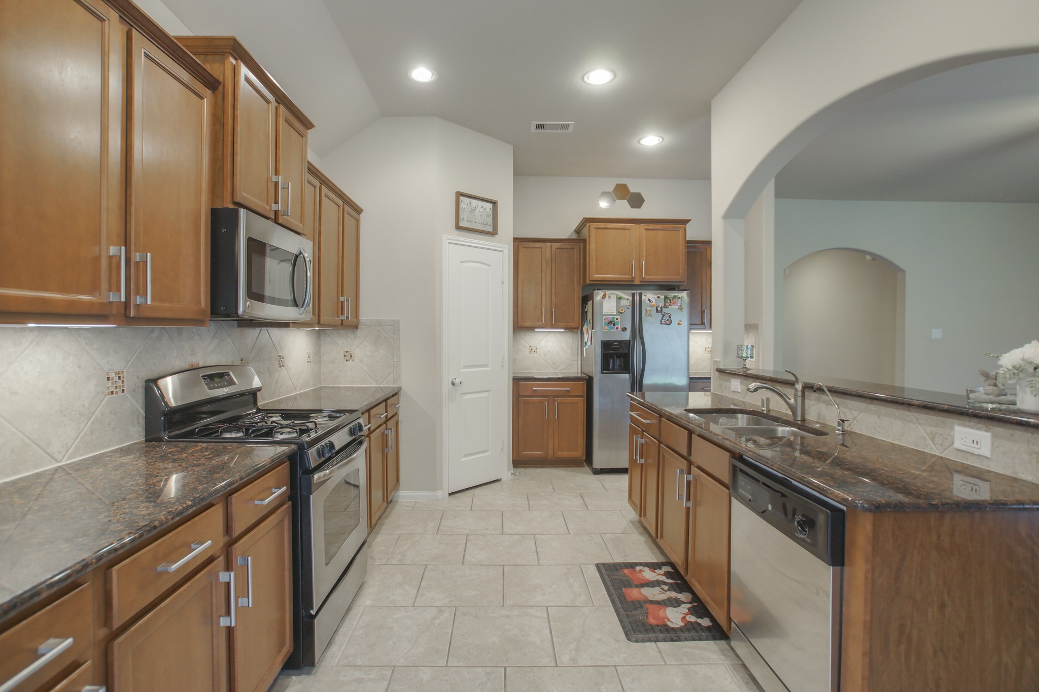 111 Pheasant Run Drive Conroe, TX 77384 - Photo 20 of 50 a kitchen with stainless steel appliances granite countertop a stove a sink and a refrigerator
