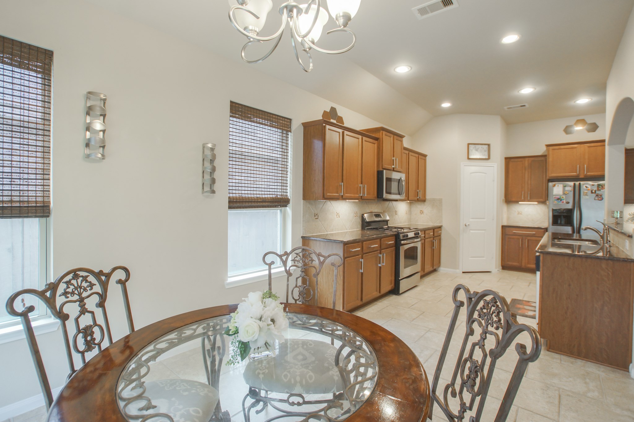 111 Pheasant Run Drive Conroe, TX 77384 - Photo 24 of 50 a kitchen with granite countertop a table chairs stove and refrigerator