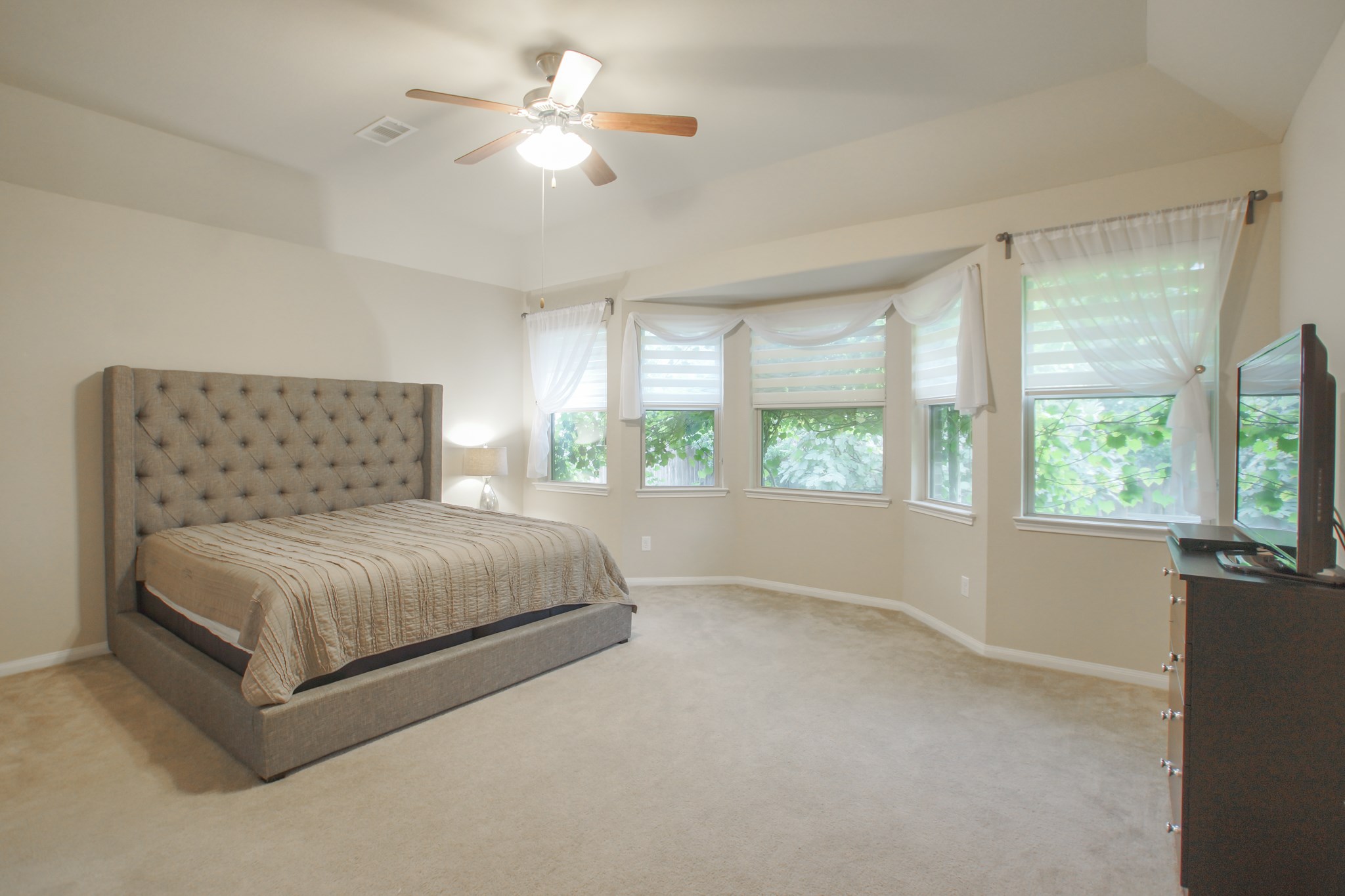 111 Pheasant Run Drive Conroe, TX 77384 - Photo 31 of 50 a bedroom with a large bed chandelier and a large window
