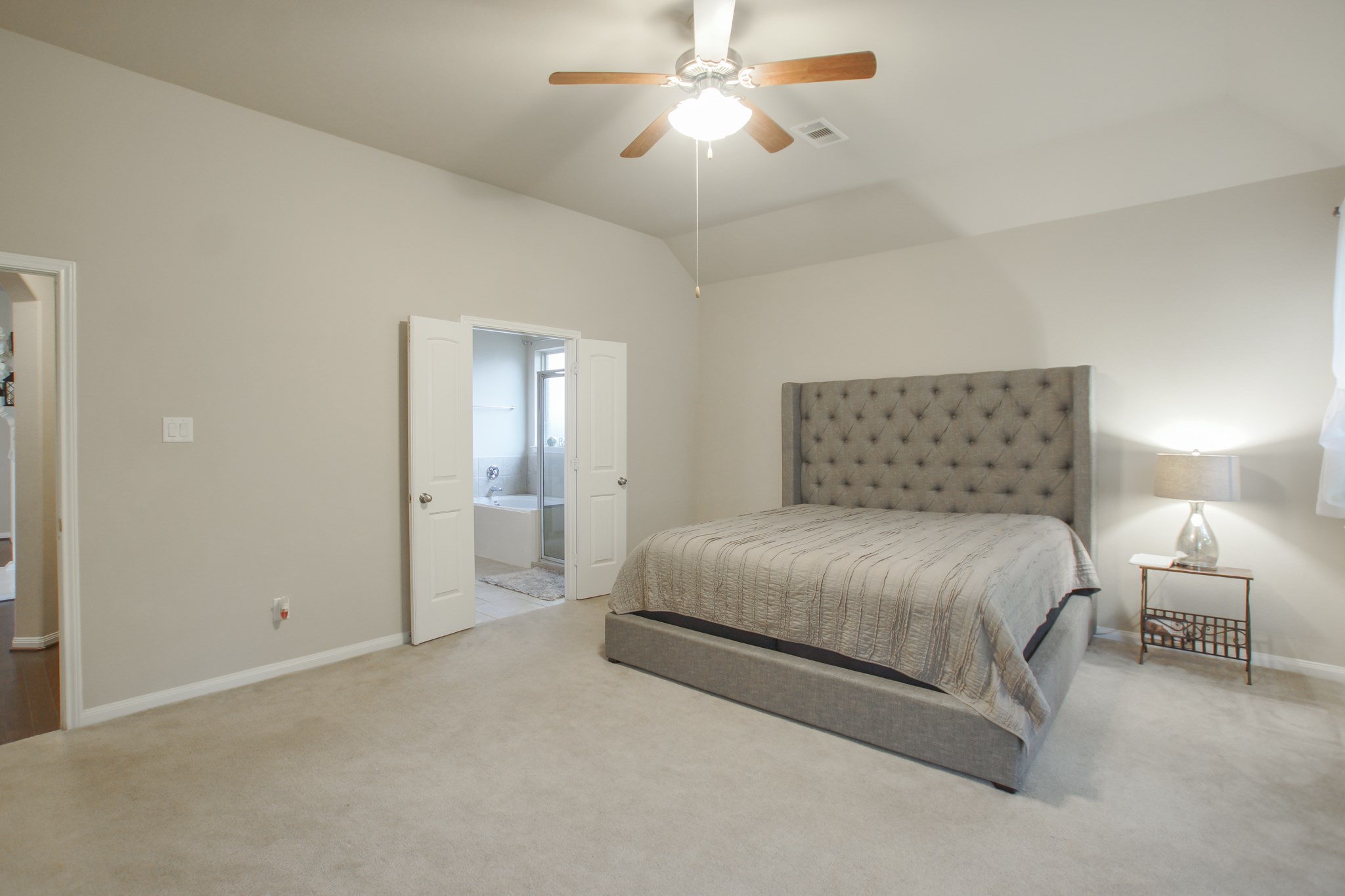 111 Pheasant Run Drive Conroe, TX 77384 - Photo 32 of 50 a bedroom with a bed and a chandelier