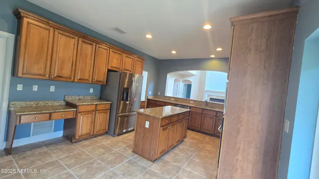 a kitchen with stainless steel appliances granite countertop a refrigerator and a stove top oven