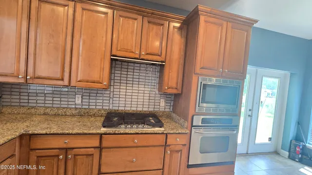 a kitchen with granite countertop cabinets stainless steel appliances and a wooden floor