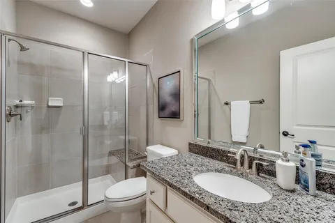 a bathroom with a granite countertop sink toilet and shower