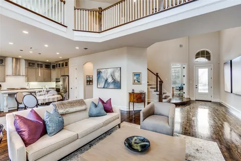 a living room with furniture a rug and kitchen view