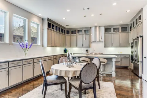 a kitchen with granite countertop a dining table chairs cabinets and stainless steel appliances