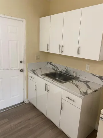 a kitchen with granite countertop white cabinets and white appliances