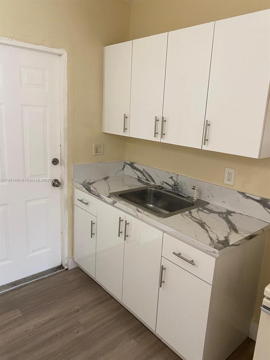 1111 Southwest 2nd Street, Unit 1111 Homestead, FL 33030 - Photo 1 of 15 a kitchen with granite countertop white cabinets and white appliances