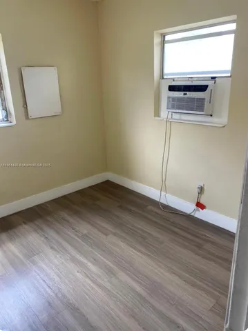 a view of a room with wooden floor and window