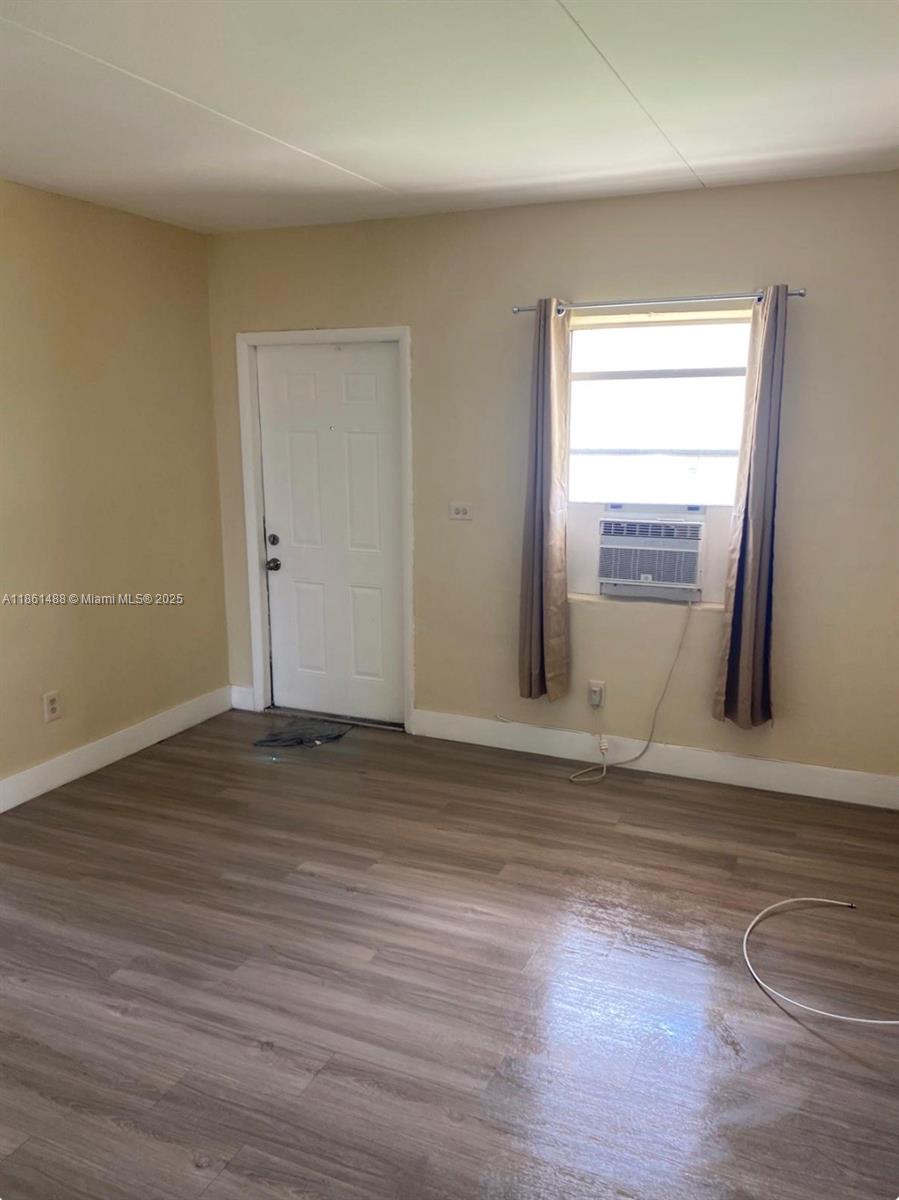1111 Southwest 2nd Street, Unit 1111 Homestead, FL 33030 - Photo 5 of 15 a view of an empty room with wooden floor and a window